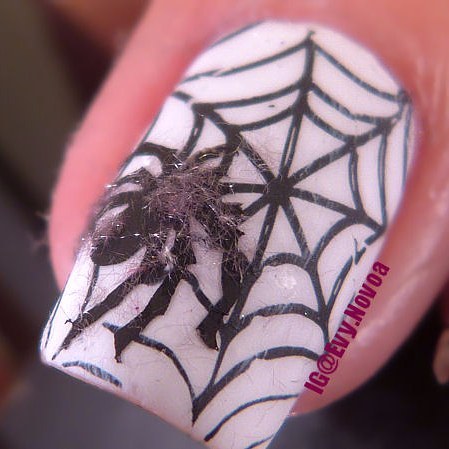 white halloween nails with a fluffy pussy spider