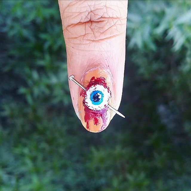 Halloween manicure with bloody eye and a nail