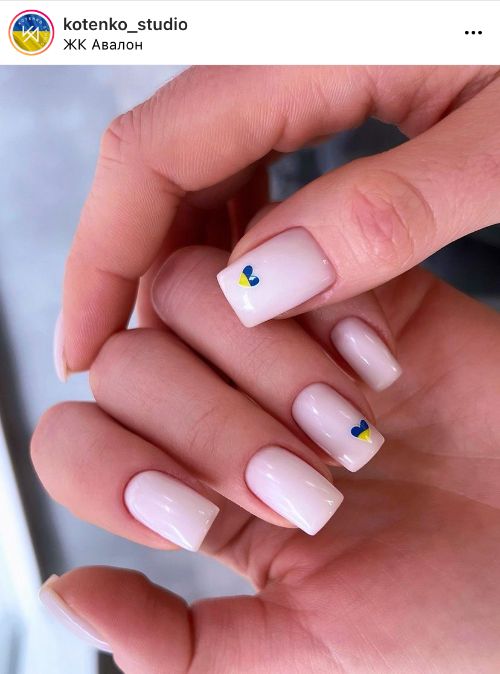 дизайн нігтів в білому кольорі з синьо-жовтими сердечками патріотичними